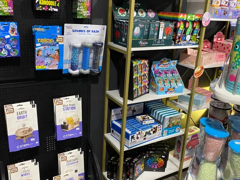STEM building kits and brain-teaser puzzles on display, including wooden mechanical models and logic games.
